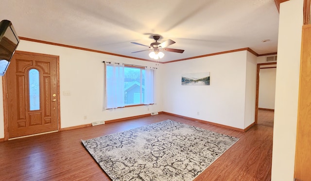 foyer with hardwood / wood-style flooring, ceiling fan, and crown molding