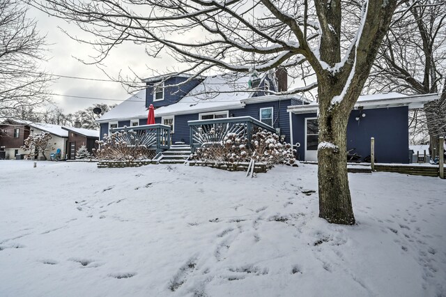 snow covered rear of property featuring a wooden deck