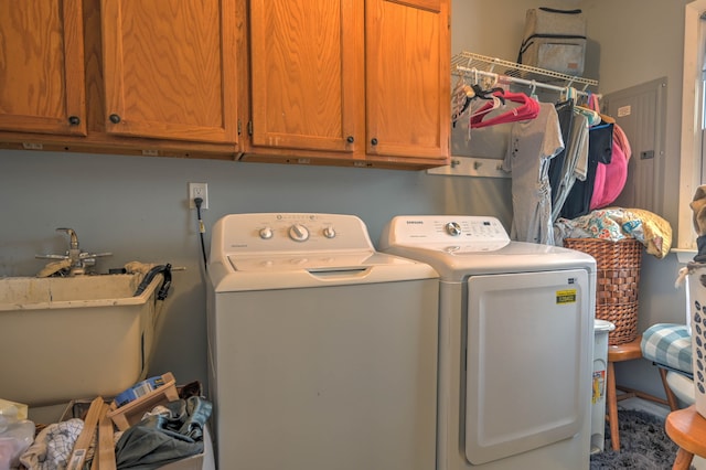 clothes washing area featuring cabinets, sink, and washing machine and clothes dryer