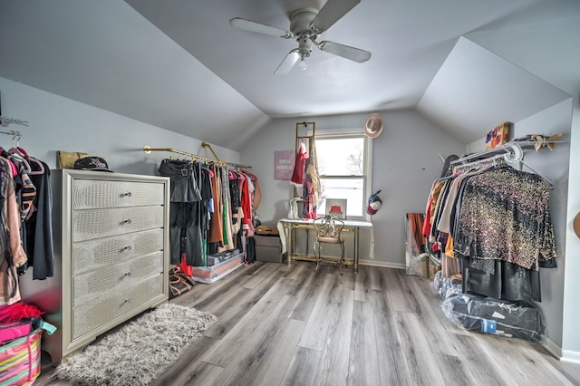 walk in closet featuring light wood-type flooring, vaulted ceiling, and ceiling fan