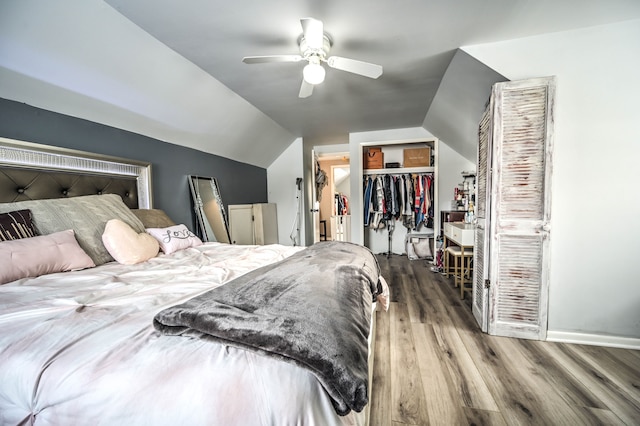 bedroom with ceiling fan, a closet, wood-type flooring, and lofted ceiling