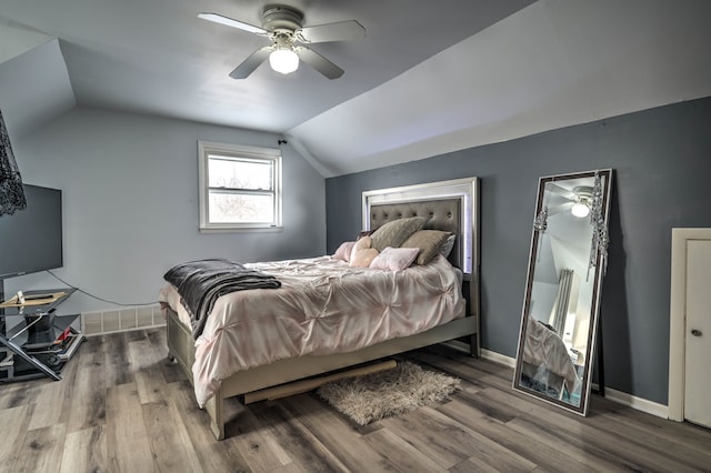 bedroom with ceiling fan, vaulted ceiling, and hardwood / wood-style flooring