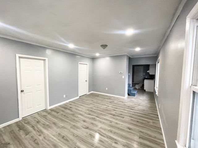 empty room with wood-type flooring and crown molding