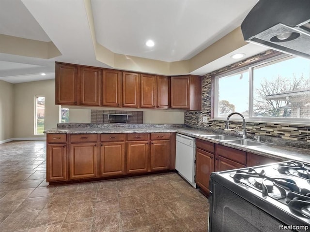 kitchen with stove, white dishwasher, tasteful backsplash, and sink