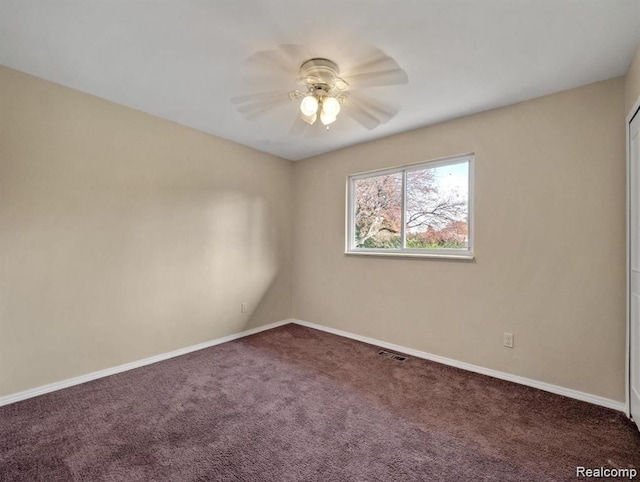 carpeted spare room with ceiling fan