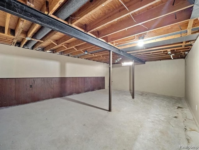 basement featuring wood walls