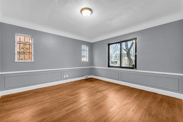 unfurnished room featuring a textured ceiling and hardwood / wood-style flooring