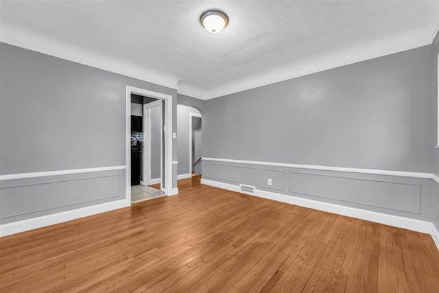 unfurnished room with light hardwood / wood-style flooring and a textured ceiling