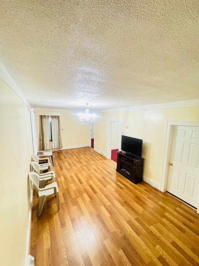 interior space with a chandelier, a textured ceiling, and wood-type flooring