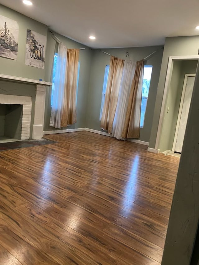 unfurnished living room featuring a fireplace and dark wood-type flooring