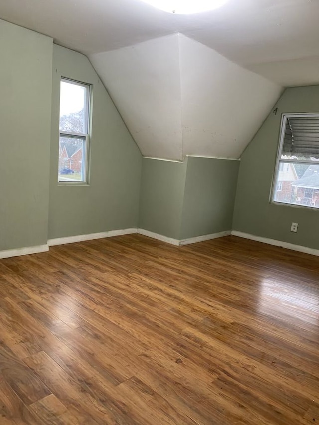 additional living space featuring hardwood / wood-style floors and vaulted ceiling