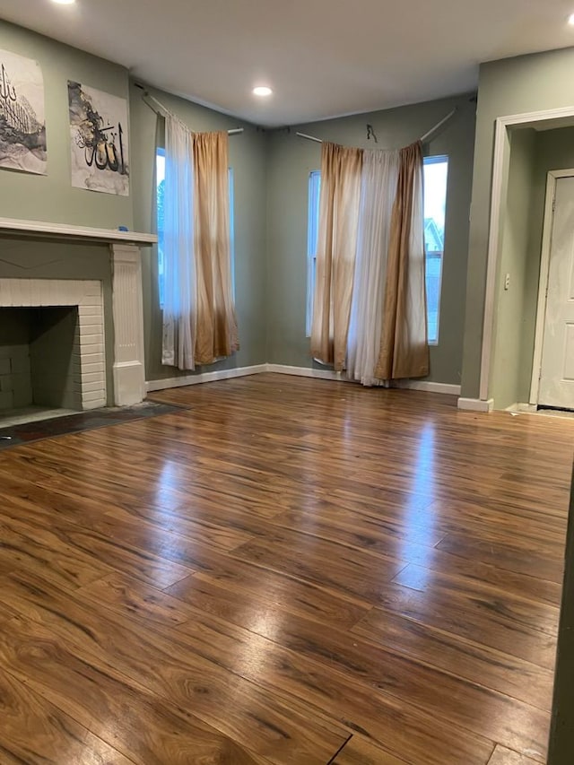 unfurnished living room featuring a fireplace and wood-type flooring