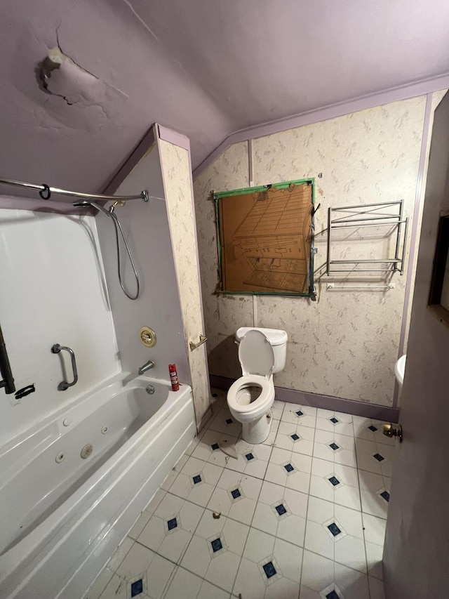 bathroom with tile patterned flooring, toilet, bathing tub / shower combination, and vaulted ceiling