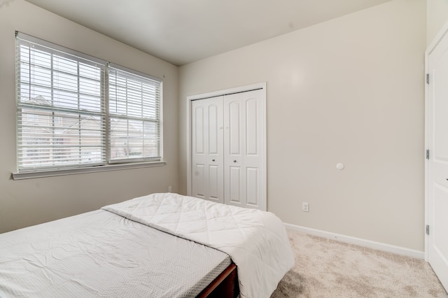 bedroom with light colored carpet and a closet