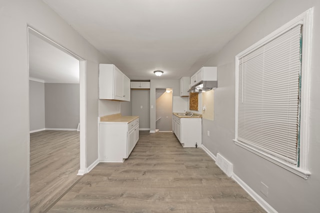 kitchen with white cabinets and light wood-type flooring