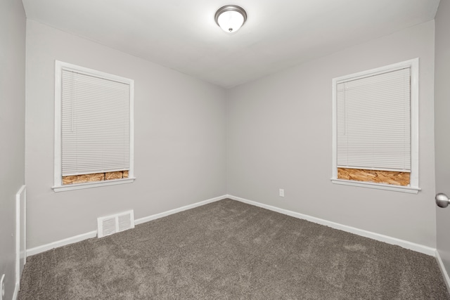 spare room featuring dark carpet