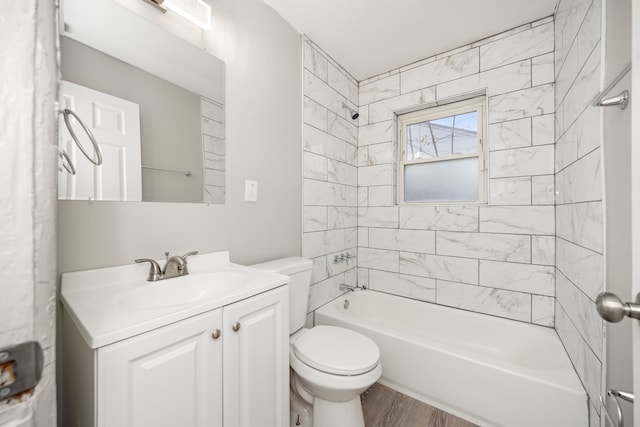 full bathroom featuring vanity, hardwood / wood-style flooring, toilet, and tiled shower / bath