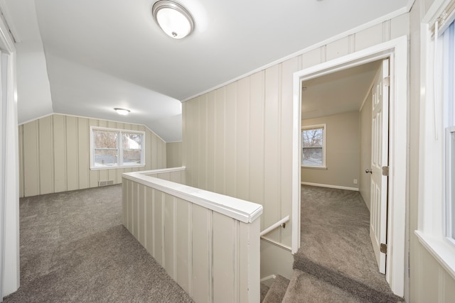 hallway featuring lofted ceiling and carpet floors