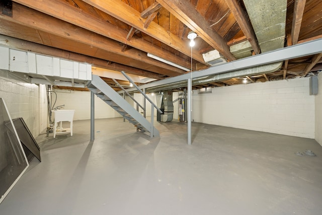 basement featuring gas water heater, heating unit, and sink