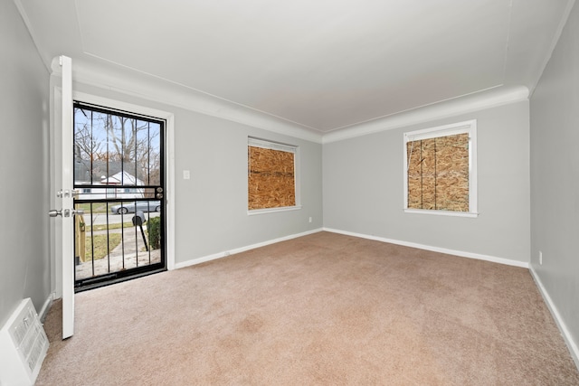 spare room featuring crown molding and light carpet