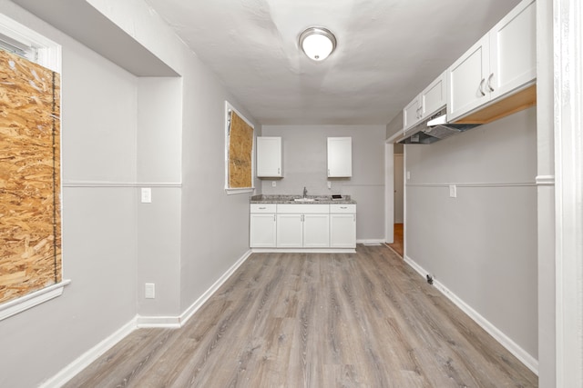 kitchen with sink, white cabinets, and light hardwood / wood-style floors