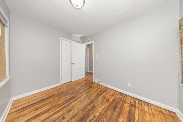 unfurnished bedroom featuring hardwood / wood-style flooring and a closet