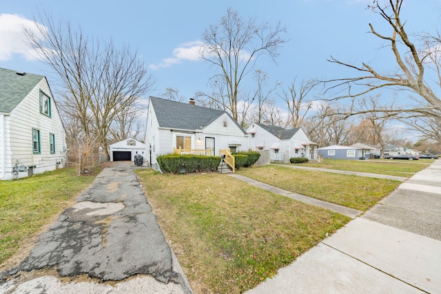 view of front of house featuring a garage, an outbuilding, and a front yard