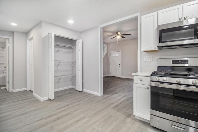 kitchen featuring ceiling fan, light hardwood / wood-style flooring, white cabinets, and stainless steel appliances