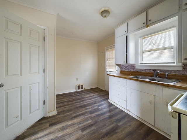 kitchen featuring sink, dark hardwood / wood-style floors, crown molding, decorative backsplash, and white cabinets