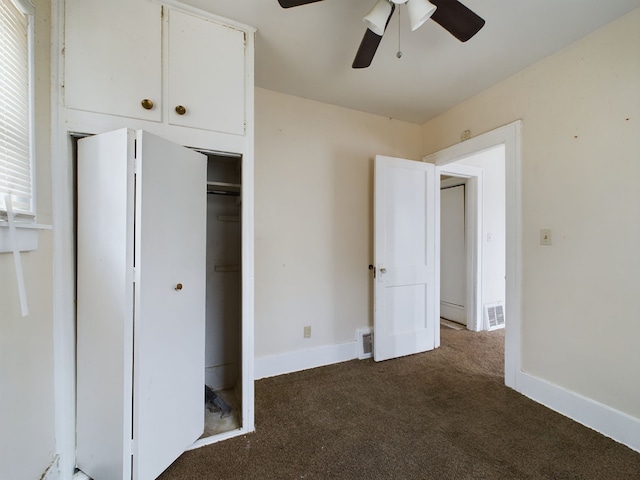 unfurnished bedroom featuring ceiling fan and dark carpet