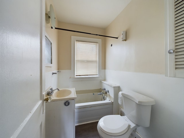 bathroom with a tub, vanity, and toilet