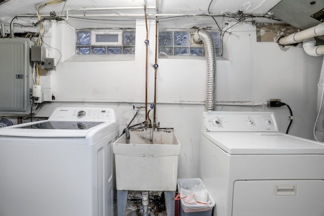 washroom with electric panel, sink, and independent washer and dryer