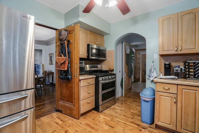 kitchen with light brown cabinetry, ceiling fan, light hardwood / wood-style flooring, and stainless steel appliances