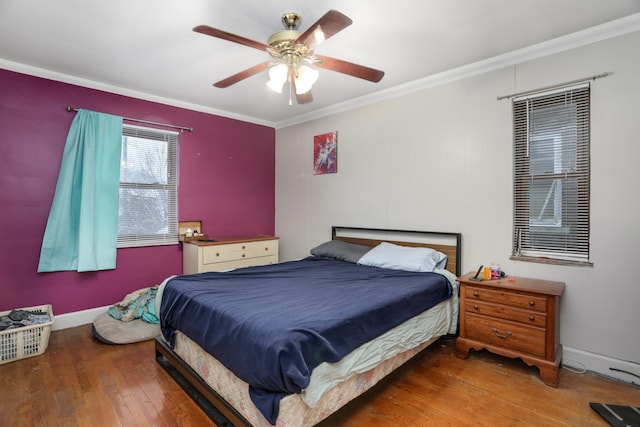 bedroom with ceiling fan, ornamental molding, and dark wood-type flooring