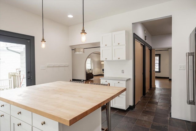 kitchen with decorative light fixtures, a center island, a barn door, and white cabinetry