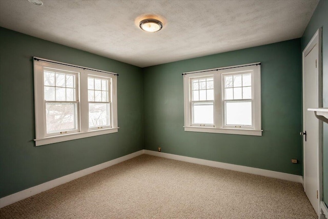 carpeted spare room featuring a textured ceiling