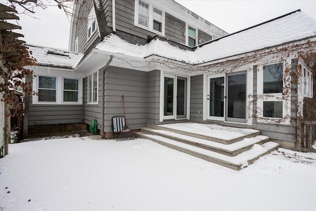 view of snow covered back of property