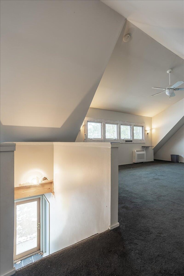 additional living space with carpet flooring, ceiling fan, vaulted ceiling, and an AC wall unit