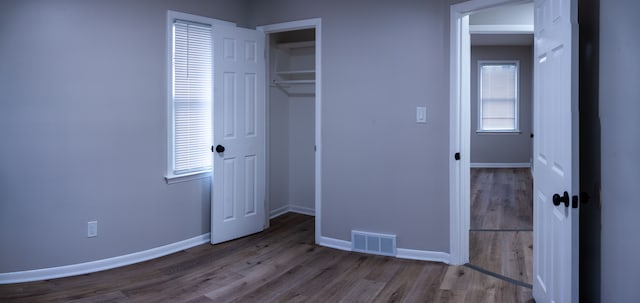 unfurnished bedroom with a closet and hardwood / wood-style flooring