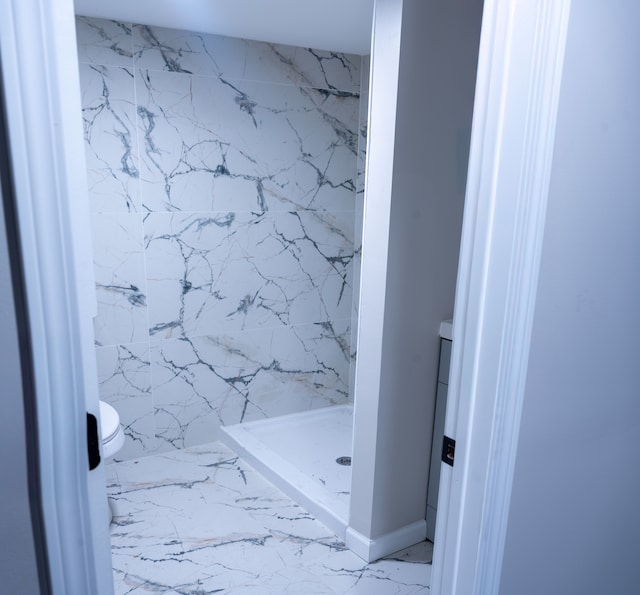 bathroom with toilet and tiled shower