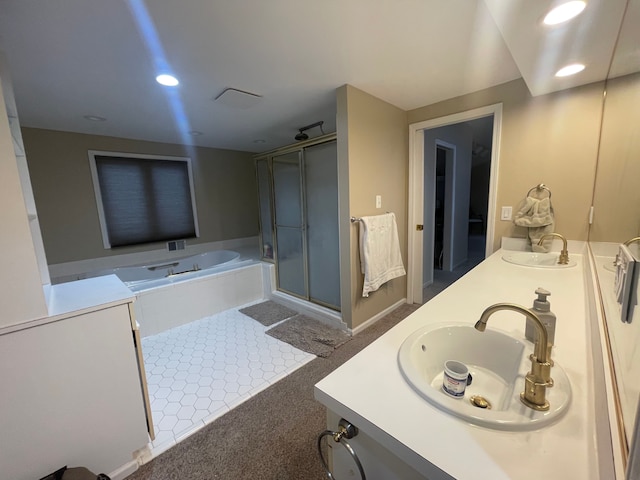 bathroom featuring vanity and independent shower and bath