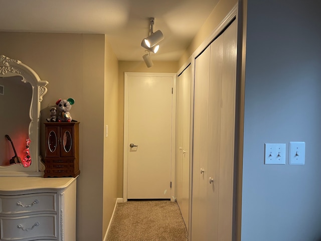 corridor featuring light colored carpet