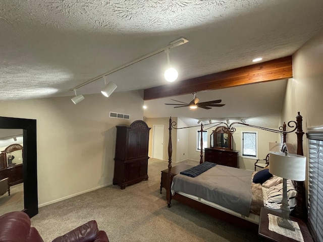 carpeted bedroom with vaulted ceiling with beams, ceiling fan, rail lighting, and a textured ceiling