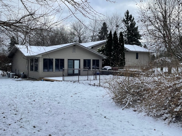 snow covered back of property featuring cooling unit