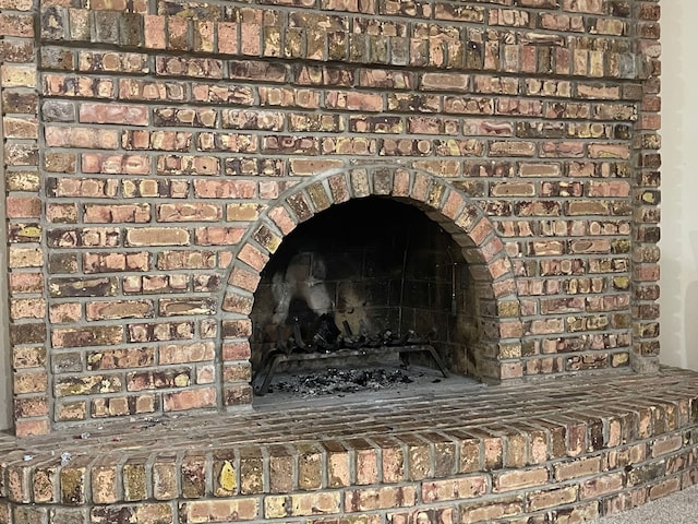 interior details featuring a brick fireplace