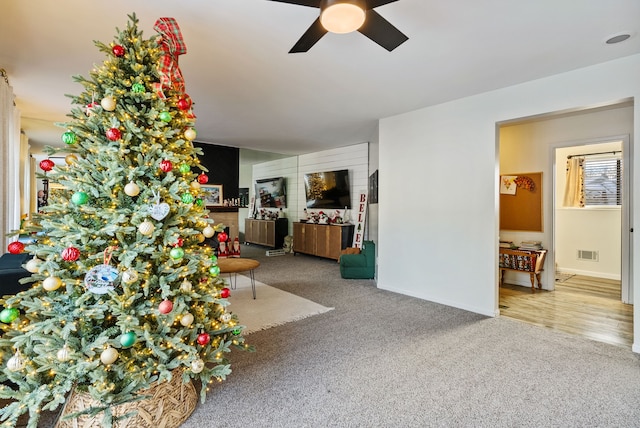 unfurnished living room featuring carpet floors and ceiling fan