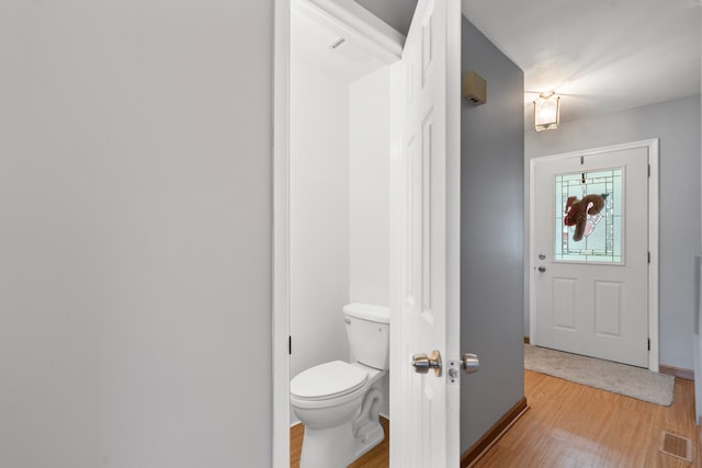 bathroom with hardwood / wood-style flooring and toilet