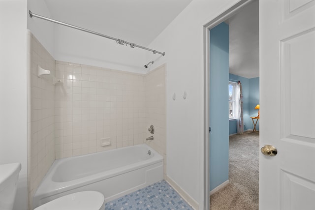 bathroom with toilet and tiled shower / bath