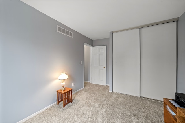 unfurnished bedroom with light carpet and a closet