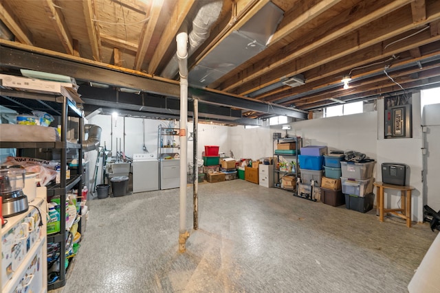 basement featuring washer and clothes dryer and electric panel